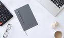 Grey notebook with a grey ballpoint pen and other corporate gift examples
