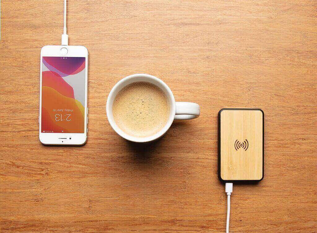 Bamboo Anti-microbial Wireless Powerbank in use on table top with coffee mug