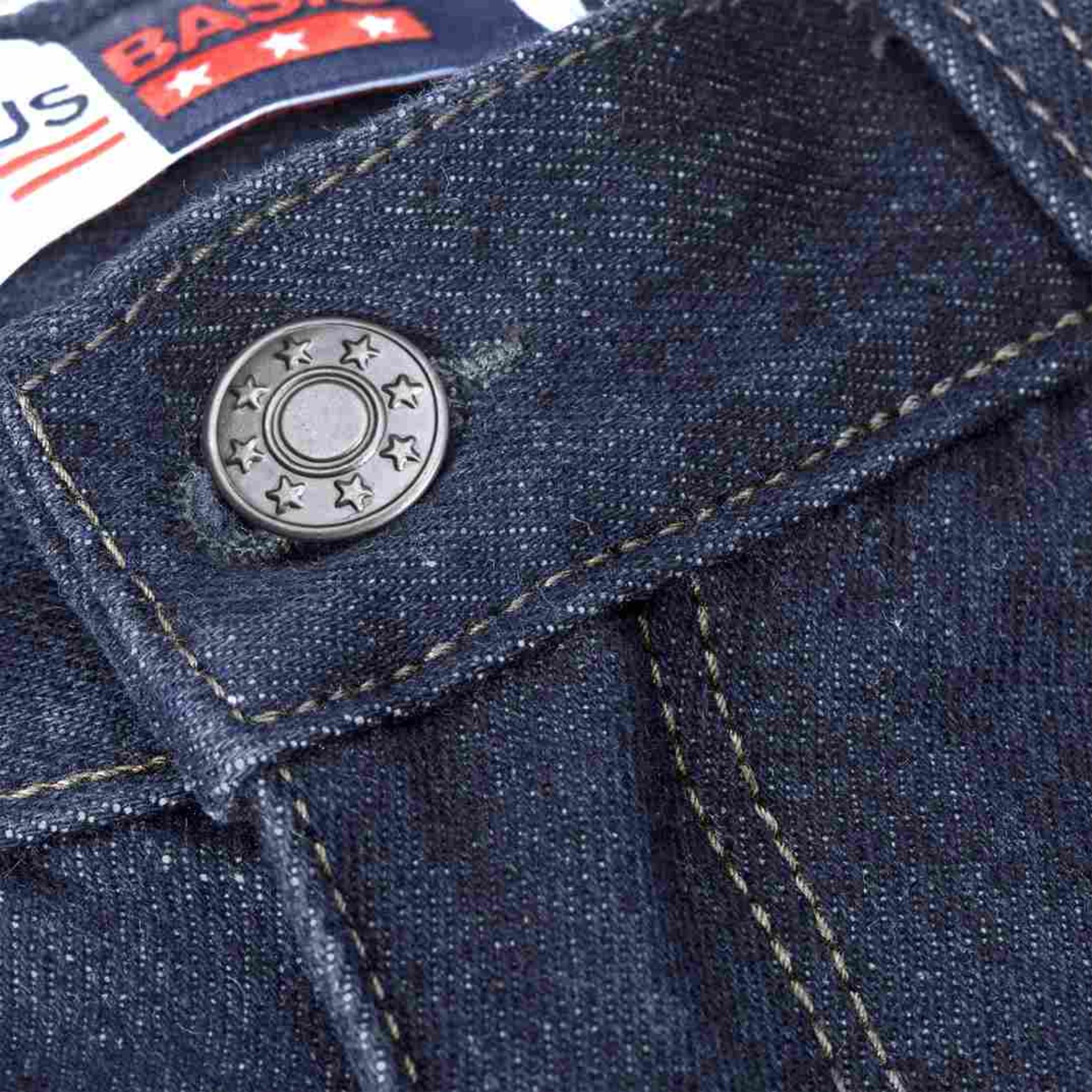 Close up of button detail of blue denim trouser pants 