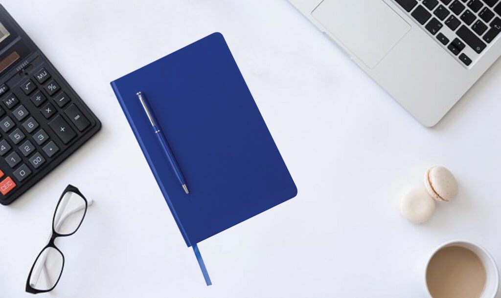 Blue notebook with a blue ballpoint pen and complimentary corporate gift examples