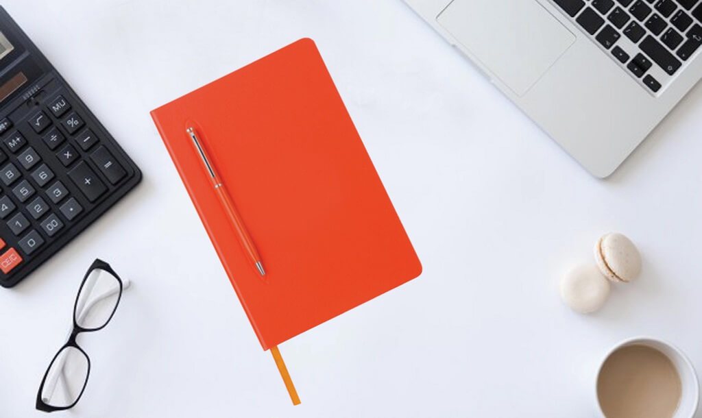 Orange notebook with an orange ballpoint pen and other example corporate gifts