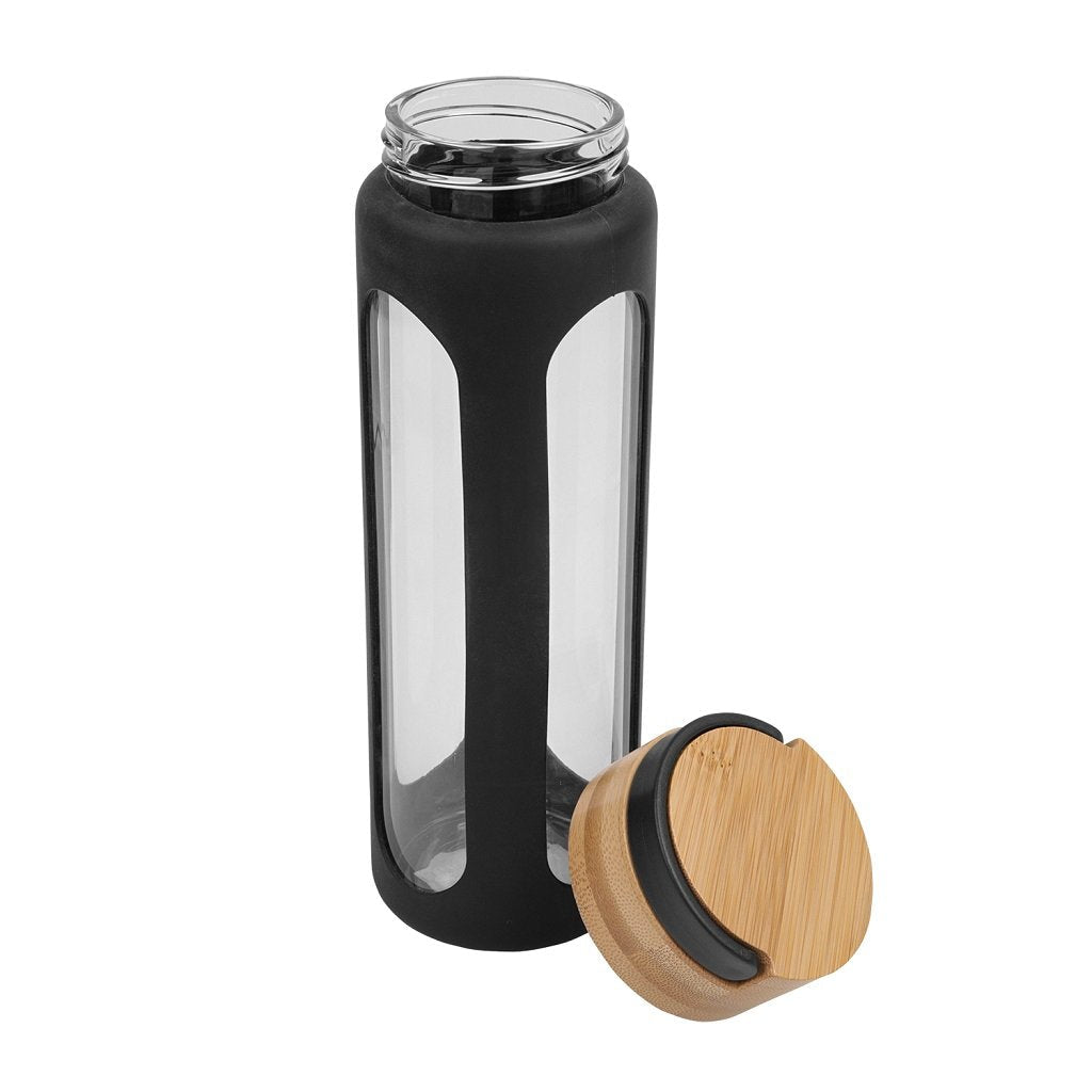 A glass bottle with the lid off on a white background